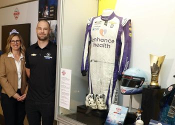 Shane van Gisbergen standing next to NASCAR Hall of Fame display