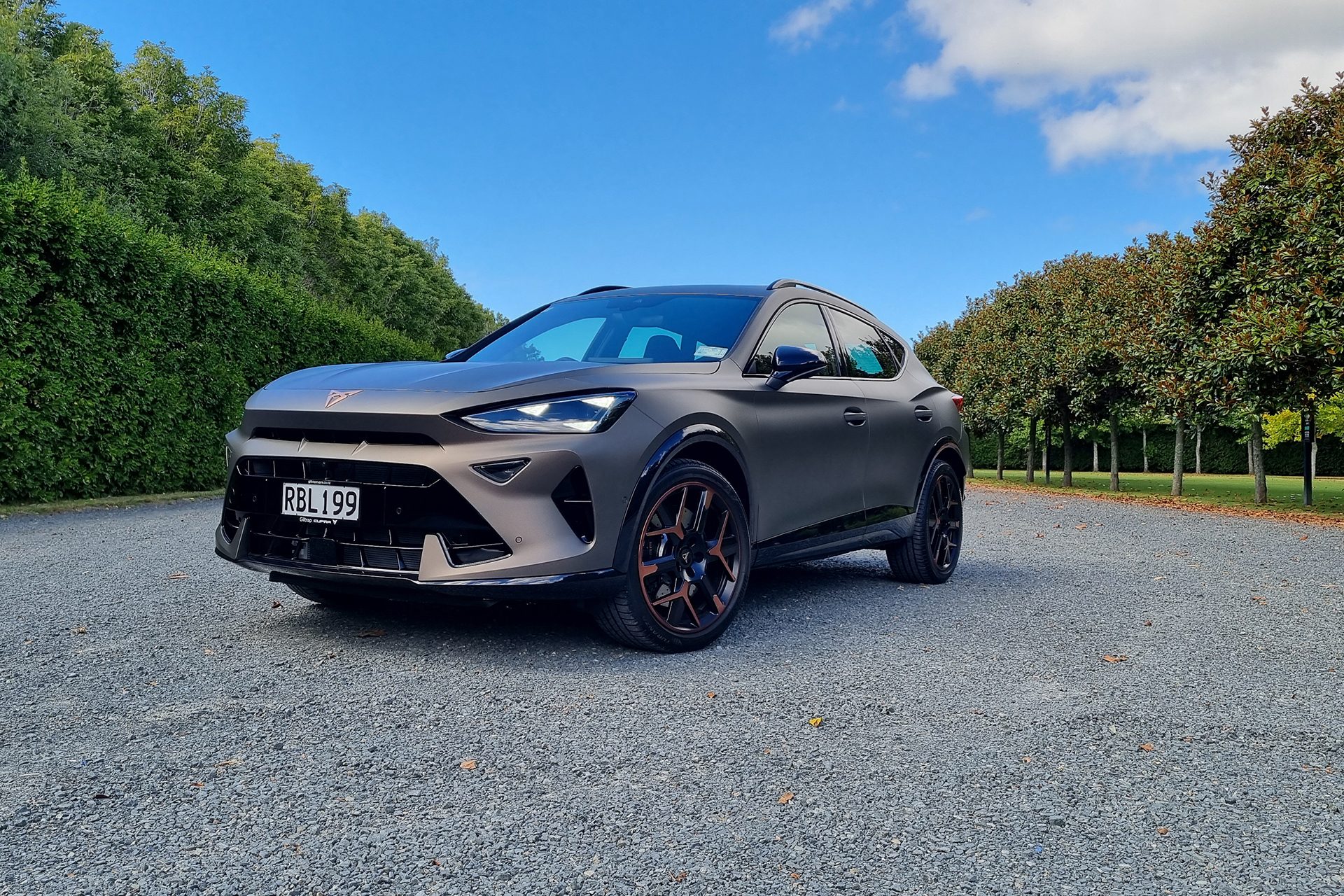 Cupra Formentor parked next to green trees