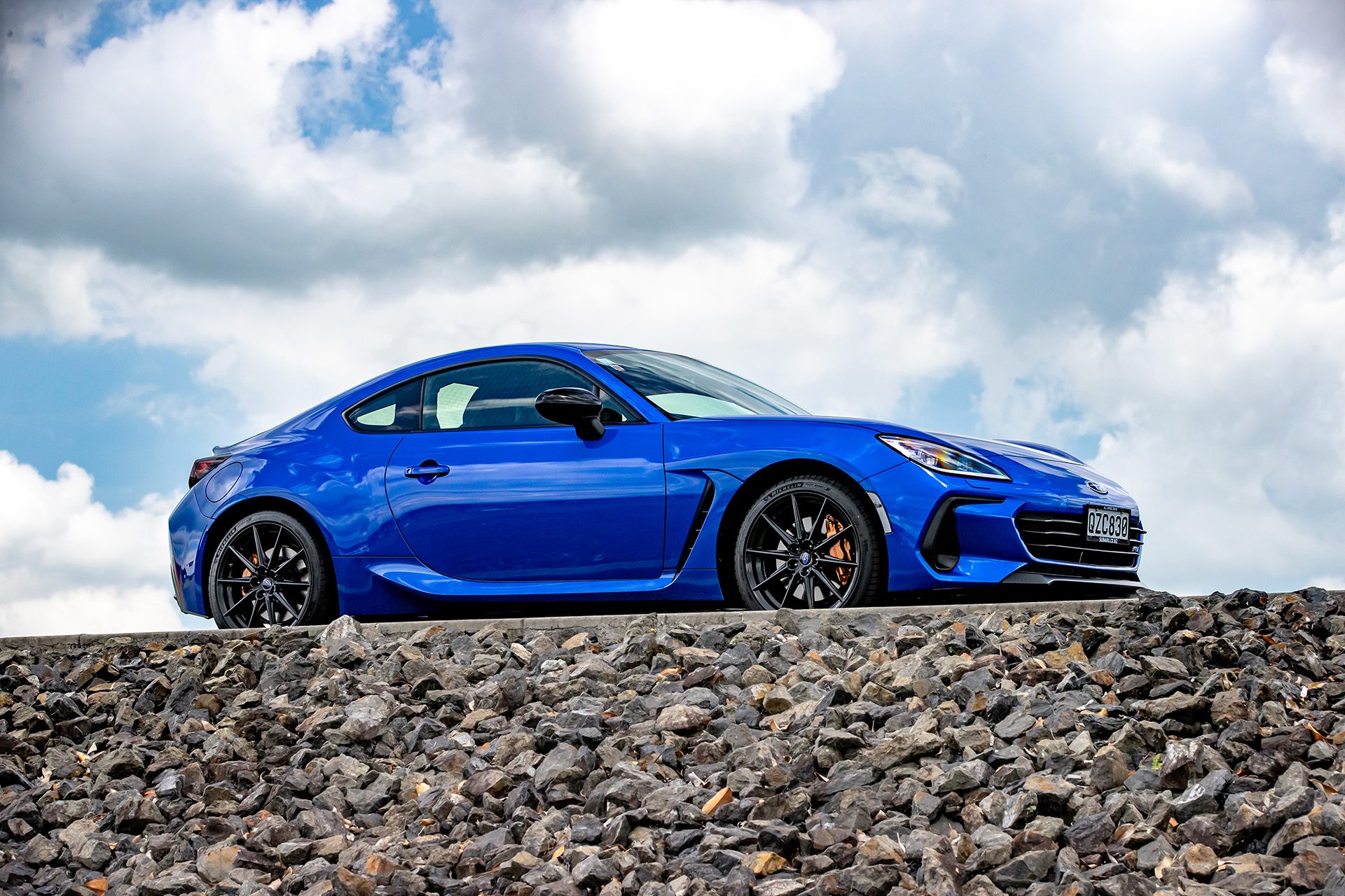 Blue Subaru BRZ under the cloudy bright sky