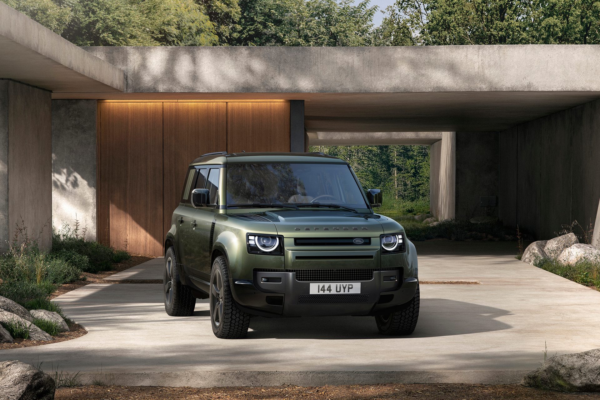 Defender in green outside a house on concrete
