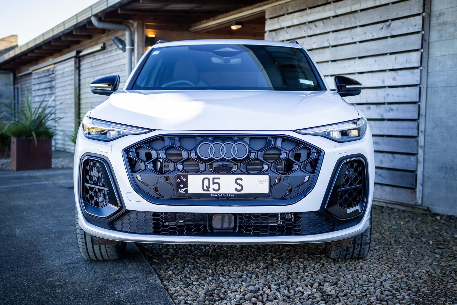White Audi Q5 by a wooden barn