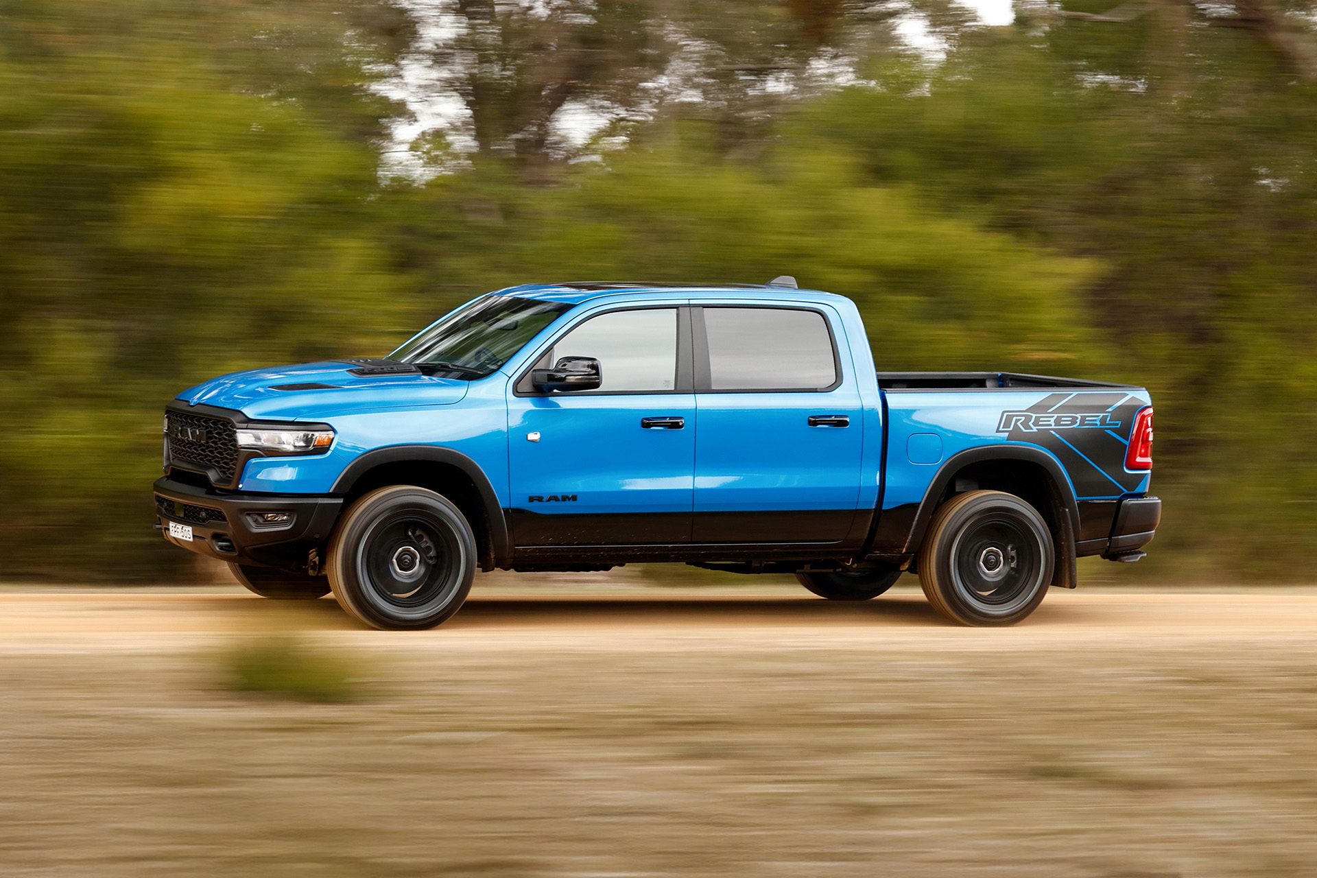Ram 1500 Rebel in blue in the green bush