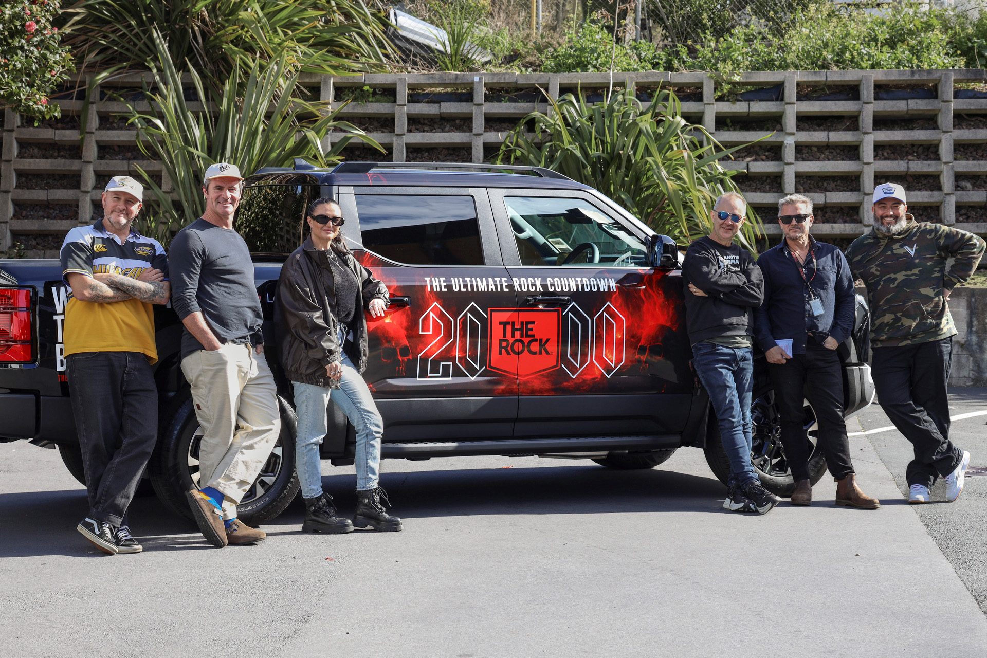 A BYD Shark with Rock livery and people standing next to it