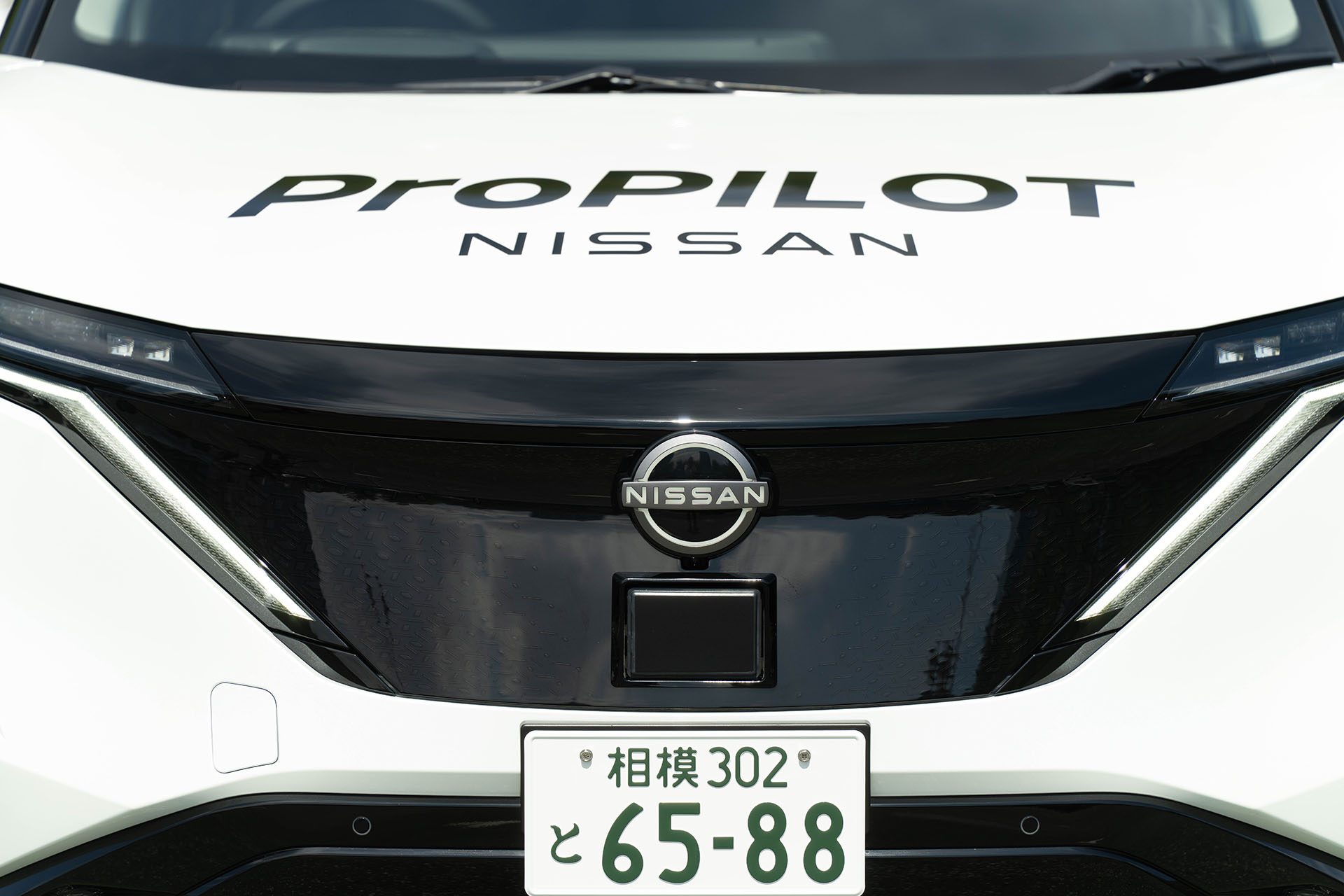 Front of a white Nissan Ariya with a Japanese number plate
