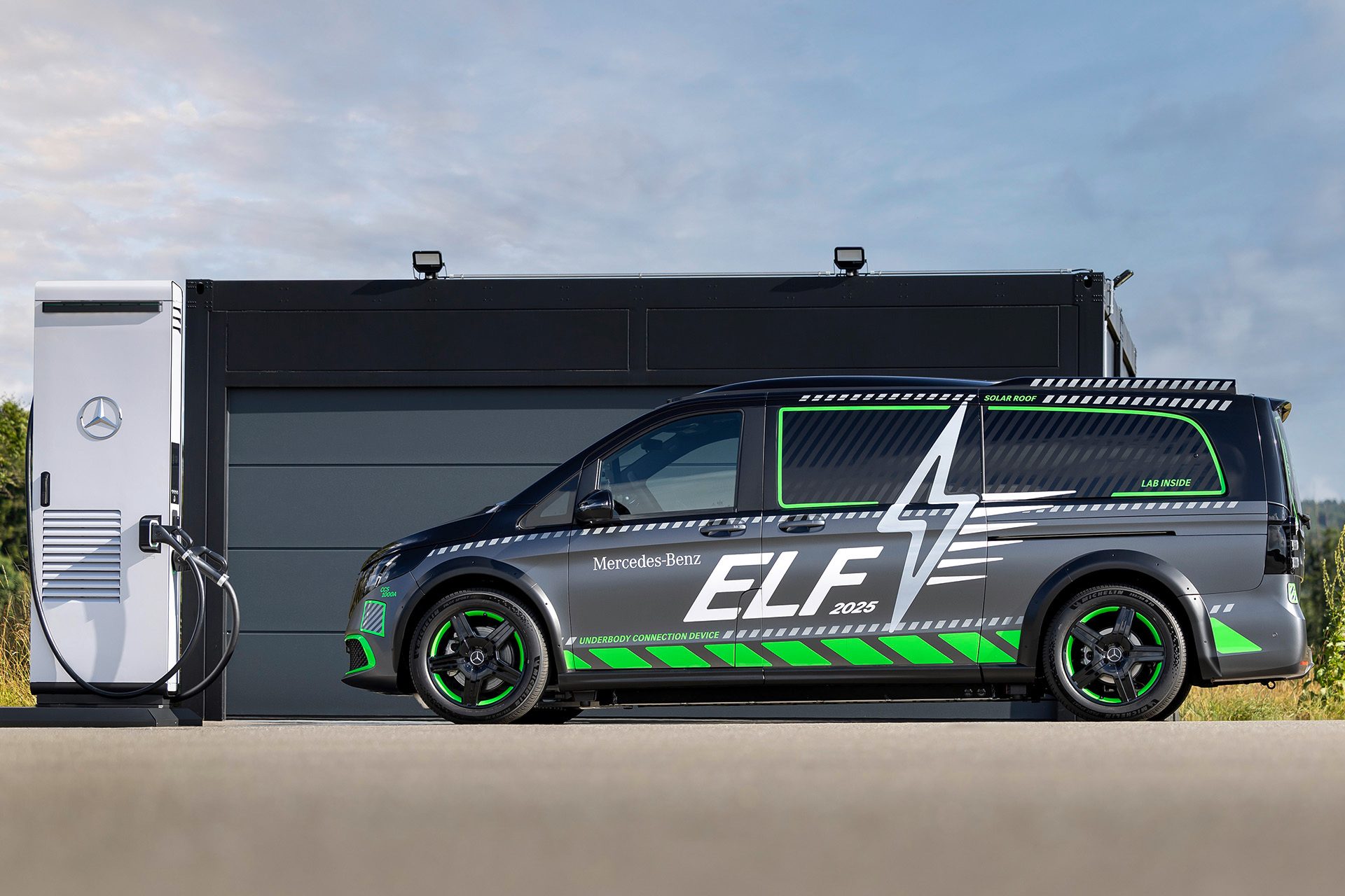 Side profile shot of Mercedes-Benz ELF parked in front of a black garage